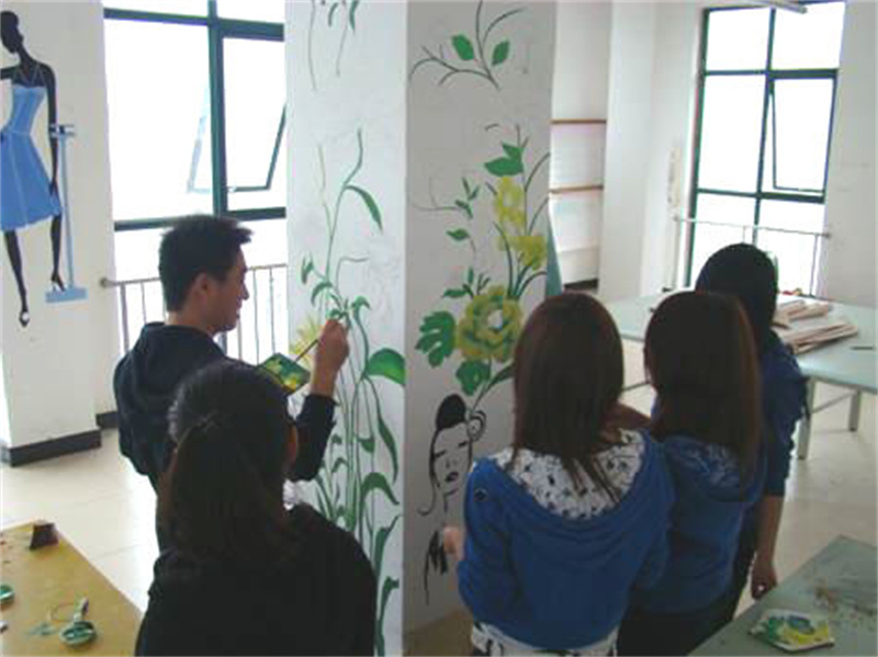 师生同心协力进行艺术楼墙面彩绘